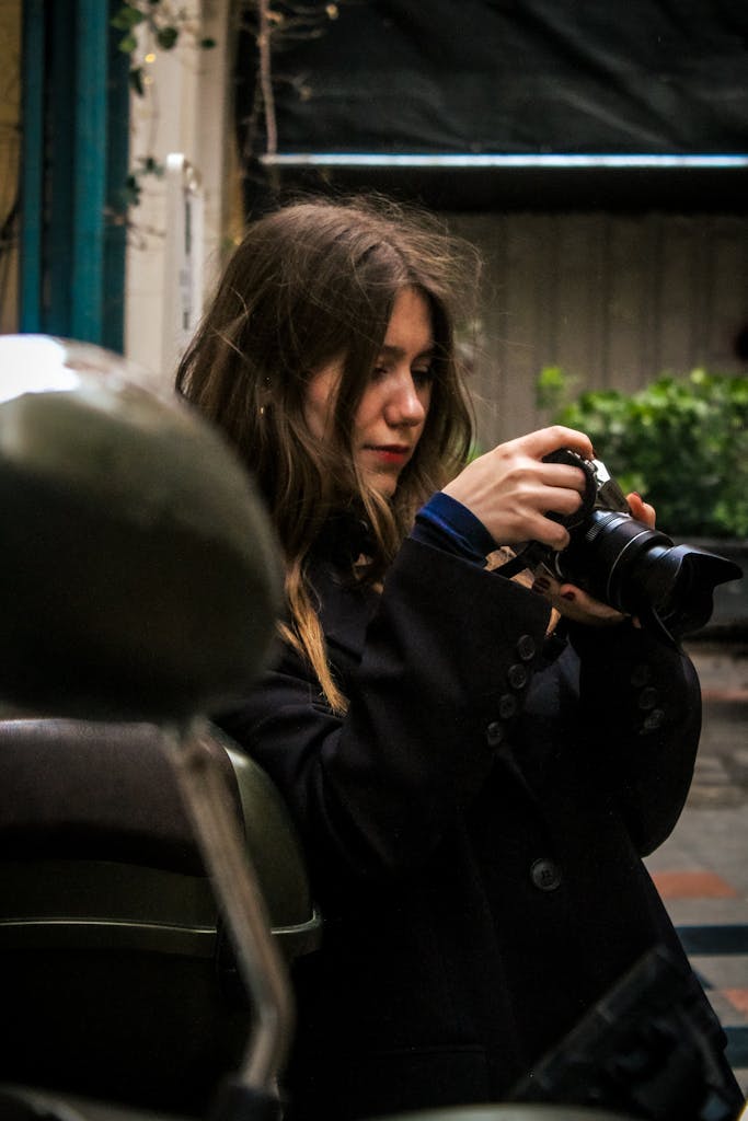 A young adult woman with a camera explores urban street photography outdoors.
